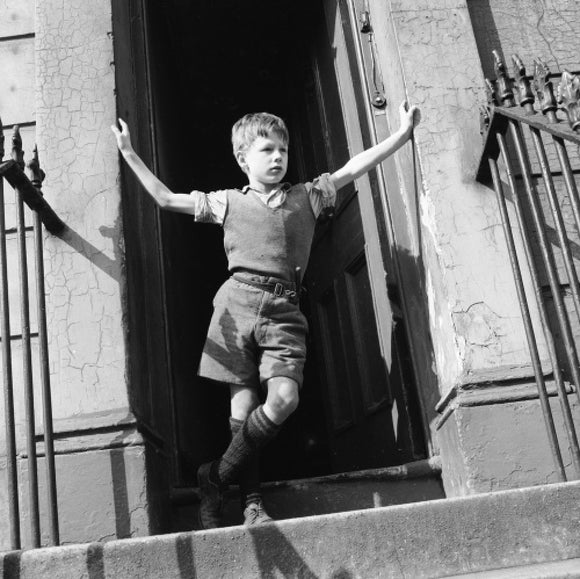 Boy standing in open doorway: 1957