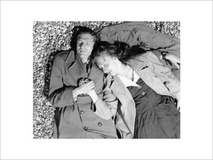 A couple lying together on Brighton Beach: c. 1955