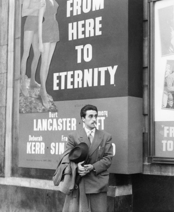 A man standing outside the Odeon cinema at Hyde Park Corner: c. 1953
