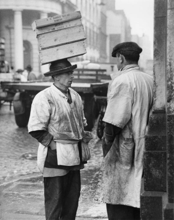 Two men in conversation outside Billingsgate Fish Market: 1958