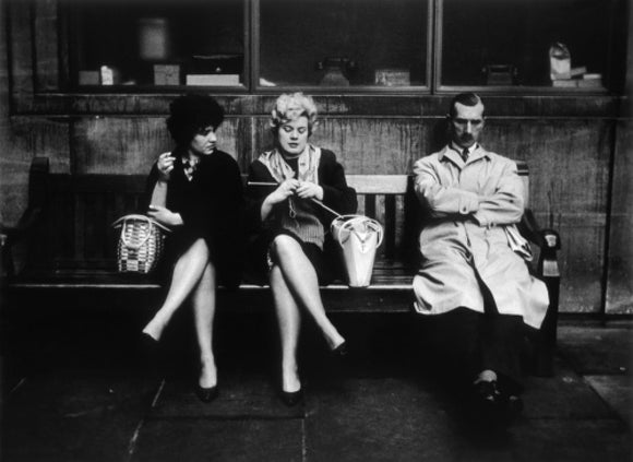 Two women and a man sit on a bench: 1961